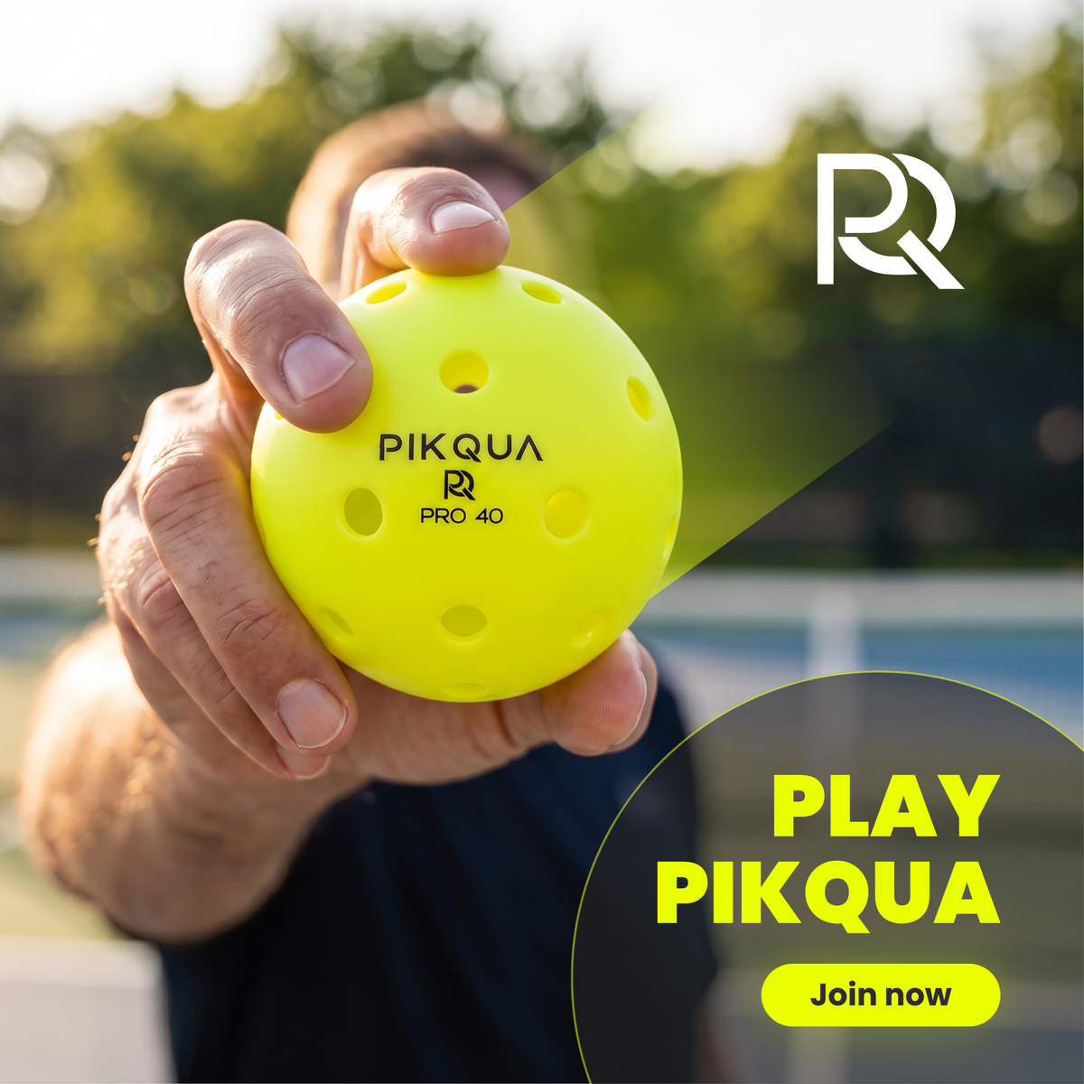 A close-up of a hand holding a bright yellow Pikqua Pro 40 pickleball against an outdoor blurred background. The image includes a white 'RR' logo in the top right and a dark circular badge with the text 'PLAY PIKQUA Join now' in the bottom right.