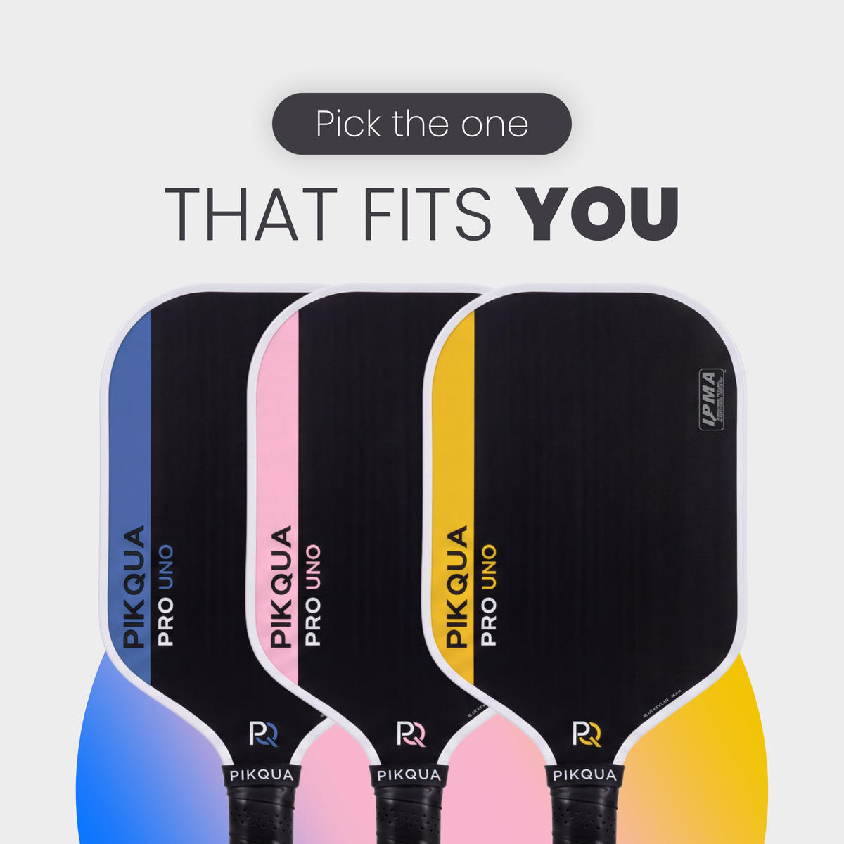 Three PIKQUA Pro Uno pickleball paddles shown side by side on a light gray background with the text 'Pick the one THAT FITS YOU' above them. The paddles have black tops with blue, pink, and yellow gradient lower sections, and the PIKQUA brand name is visible on each paddle.