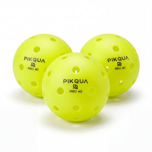 Three bright yellow pickleball balls with perforations, branded PIKQUA PRO 40, arranged on a clean white background.