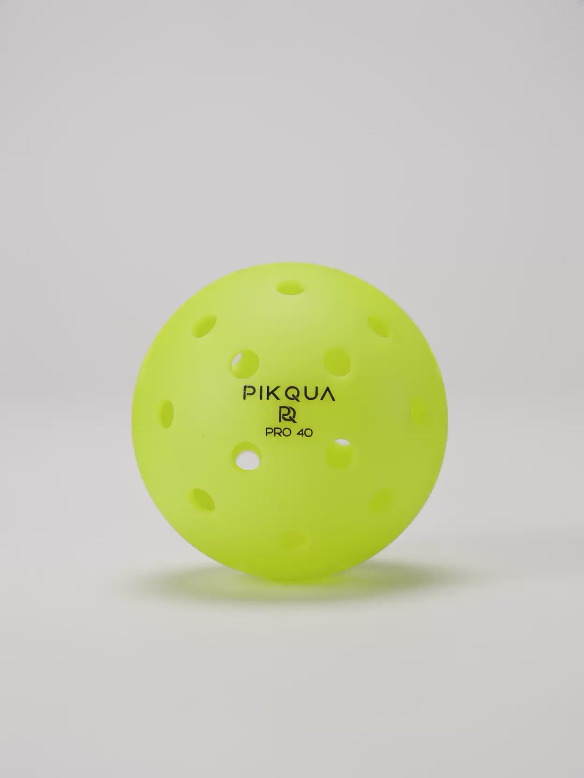Video of a bright yellow pickleball with perforations, rotating, branded PIKQUA PRO 40, arranged on a clean white background.