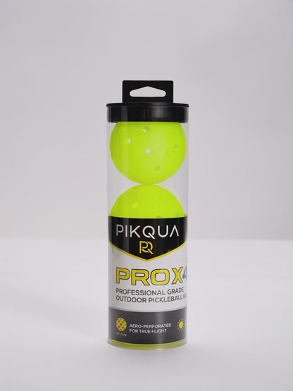 A video of a package of three bright neon yellow pickleballs in a clear cylindrical plastic case with a black lid and a black-and-yellow PIKQUA PROX4 label, photographed on a white background.